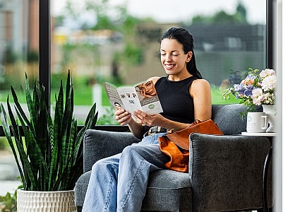Woman reading in a cozy chair indoors.