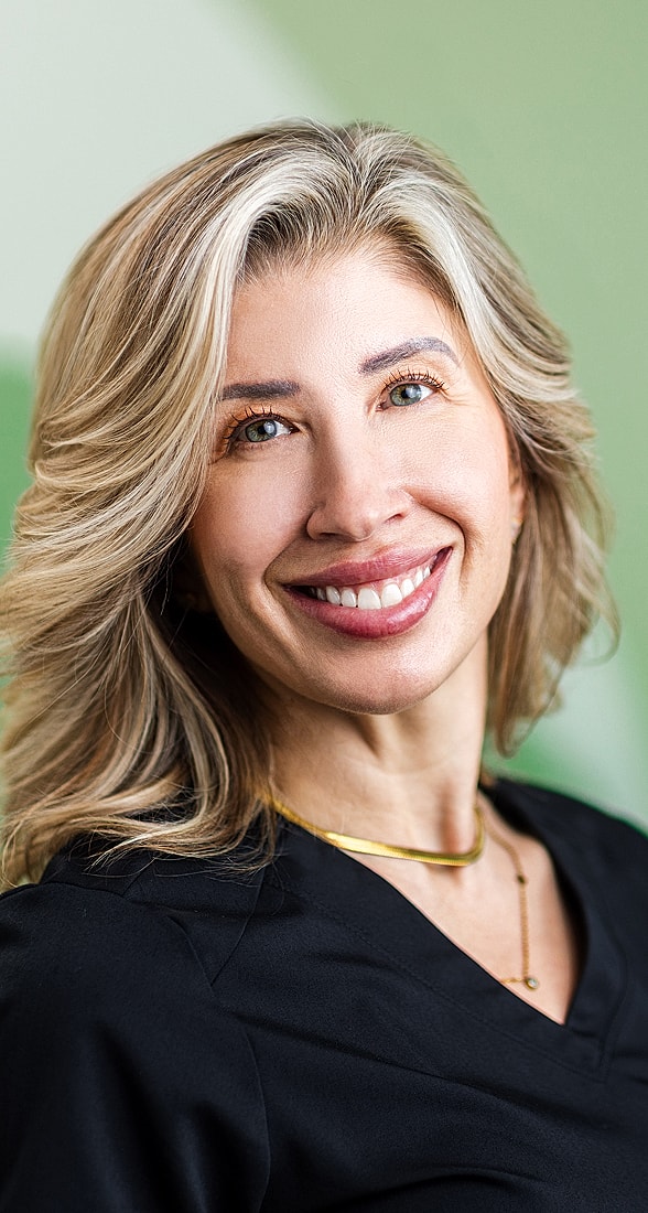 Smiling woman with blonde hair and black attire.